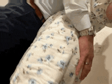 a man wearing a watch is holding a woman 's butt in his arms .