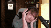 a man wearing headphones is sitting in front of a microphone with a youtube logo on the wall behind him