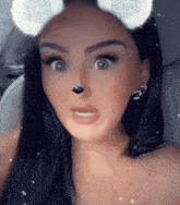 a woman with snowflakes on her ears is making a face