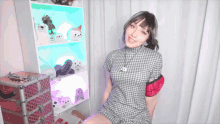 a woman in a plaid dress is sitting in front of a shelf full of stuffed animals
