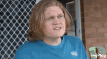 a young man with red hair is wearing a blue shirt that says imgplay on the bottom