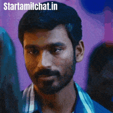 a man with a beard is looking at the camera and the website starttamilchat.in is visible behind him