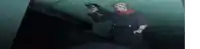 a man is standing in a dark room holding a gun in his hand .