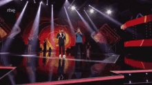 two men singing on a stage with a rtve logo in the corner