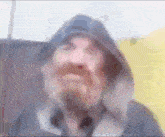 a blurry picture of a man with a beard wearing a hood .