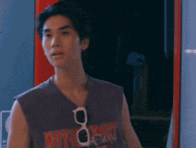 a young man wearing a purple tank top with the word moto on it .