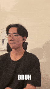 a young man wearing glasses and a black shirt with the word bruh on the bottom
