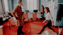 a man and a woman are standing in a room with red carpet