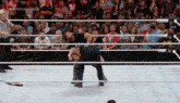 a wrestling match is taking place in front of a crowd