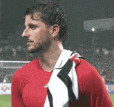 a man in a red shirt with a black and white towel around his neck