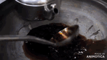 a spoon is being used to stir a brown liquid in a pan with the words made in animotica below it
