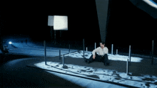 a man sits on the ground in front of a sign that says " yuta j "