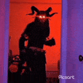a demon with horns is standing in a doorway in a room .