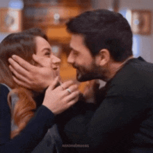 a man and a woman are kissing and the man is wearing a ring on his finger