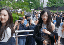 a girl wearing a t-shirt that says xxi stands in front of a crowd of people