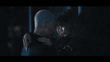 a man and a woman are looking into each other 's eyes in a dark room