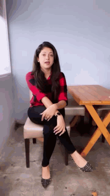 a woman in a plaid shirt is sitting in a chair with her legs crossed