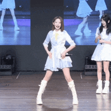 a woman in a blue and white dress stands on one leg on a stage
