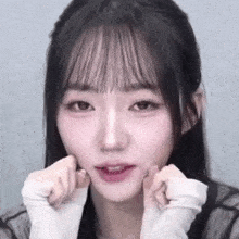 a close up of a young woman making a face with her hands on her face .