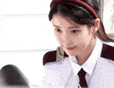 a woman in a white shirt and tie is looking at herself in the mirror