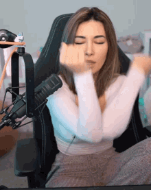 a woman is sitting in front of a microphone and making a face