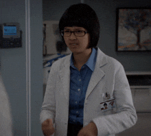 a woman in a lab coat has a name tag that says ' a. '