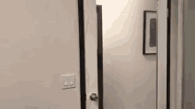 a person is walking through a hallway with a door open .