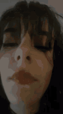 a close up of a woman 's face with red lipstick and a tear in her eye .