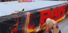 two women are wrestling in a ring with a banner that says raw on it