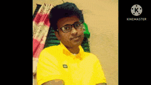 a young man wearing glasses and a yellow shirt with the word hugo on it