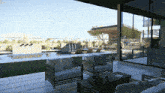 a patio with chairs and a table with a view of a swimming pool