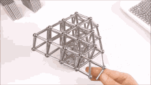 a person is holding a piece of metal that looks like a cage