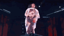 a woman singing into a microphone while wearing a shirt that says ' billie eilish '