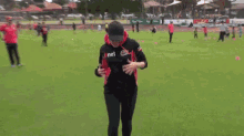 a man is running on a soccer field with a net shirt on .