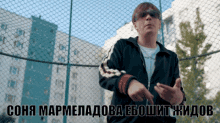 a man wearing sunglasses stands in front of a chain link fence with the words sona marmeladoba eboshit jidob