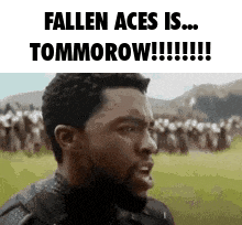 a man with a beard is standing in front of a crowd of people and says fallen aces is tomorrow .