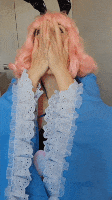 a woman with pink hair and bunny ears covering her face