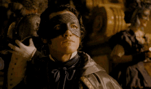 a man wearing a black mask and a black jacket looks at the camera