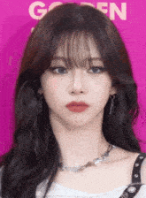 a close up of a woman 's face with a pink background and the letter n on it