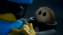 a toy with a face on it is being held by a ninja