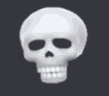 a white skull with a smile on its face on a dark background .