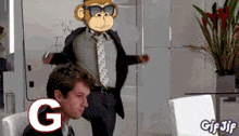 a man in a suit and tie is sitting in front of a white board with a monkey on it
