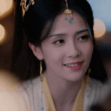 a close up of a woman 's face with a crown on her head and earrings