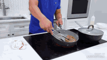 a man in a blue shirt is cooking a steak in a frying pan on an induction stove top