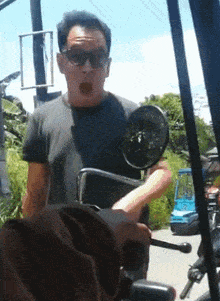 a man wearing sunglasses is holding a briefcase while riding a scooter