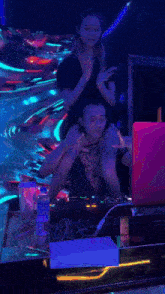 a woman is sitting on a man 's shoulders in a night club