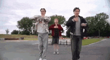 a group of young men are dancing together in a parking lot .