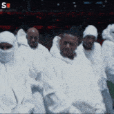 a group of people wearing white with a s on the bottom