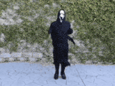 a person in a scream costume is dancing
