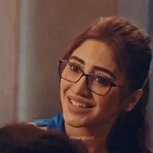 a close up of a woman wearing glasses smiling .